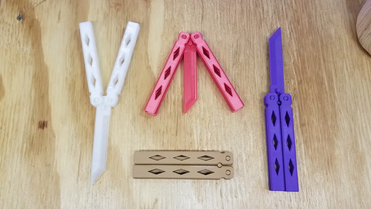 Blunt printed butterfly knives in white, pink and purple