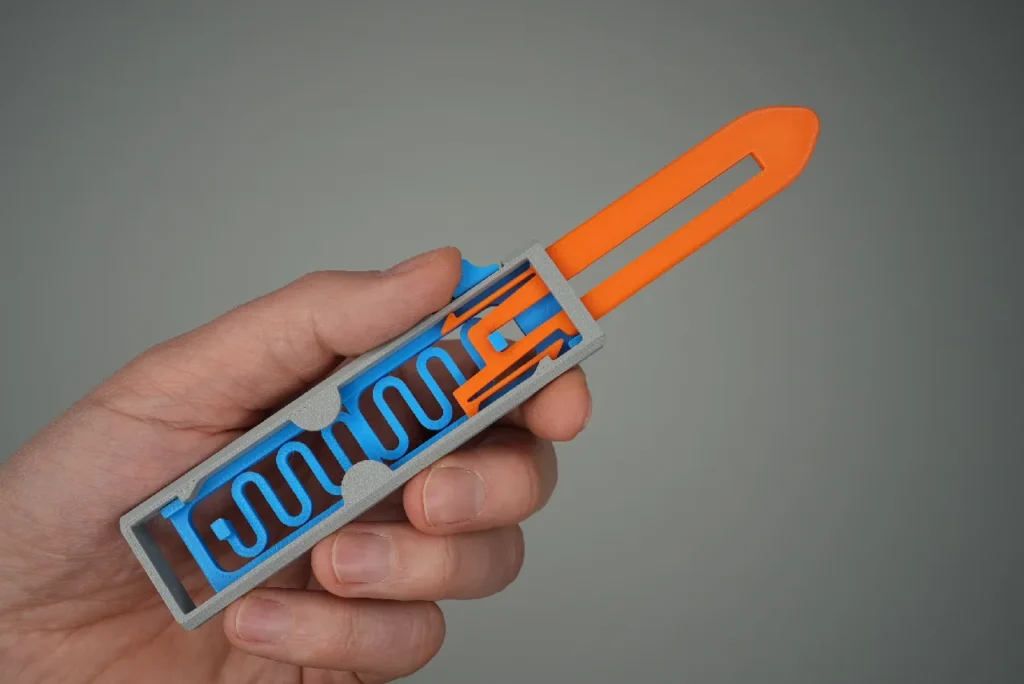 ForgeFi Flip Knife held in a hand, a blunt printed flip knife with a sliding blade and an exposed track mechanism